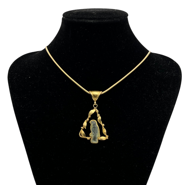Gold necklace with a bird pendant on a black mannequin bust